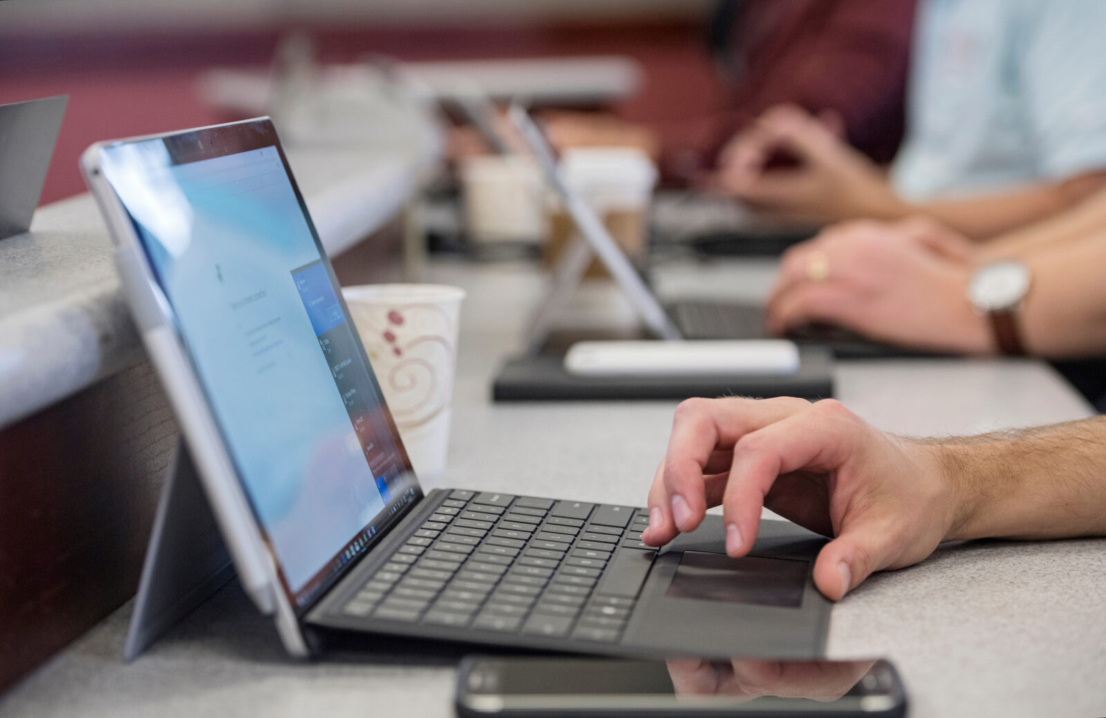 Closeup of a student using a computer during a class.